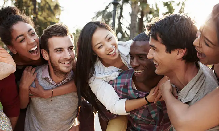 Smiling friends supporting each other during addiction recovery